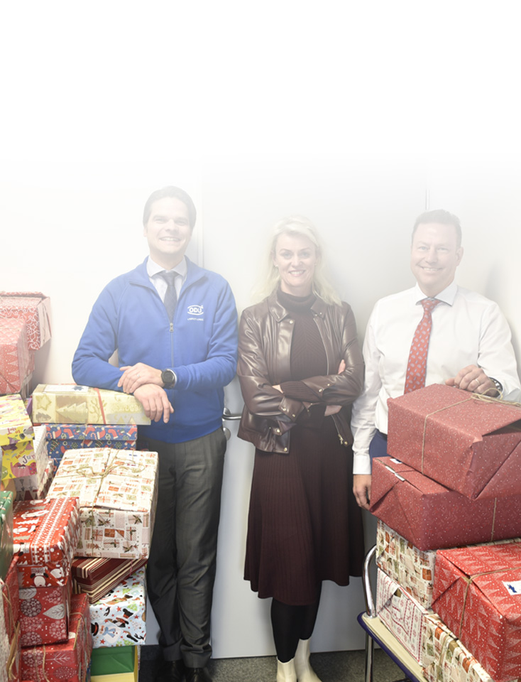 Three ODU executives in a room full of gifts.